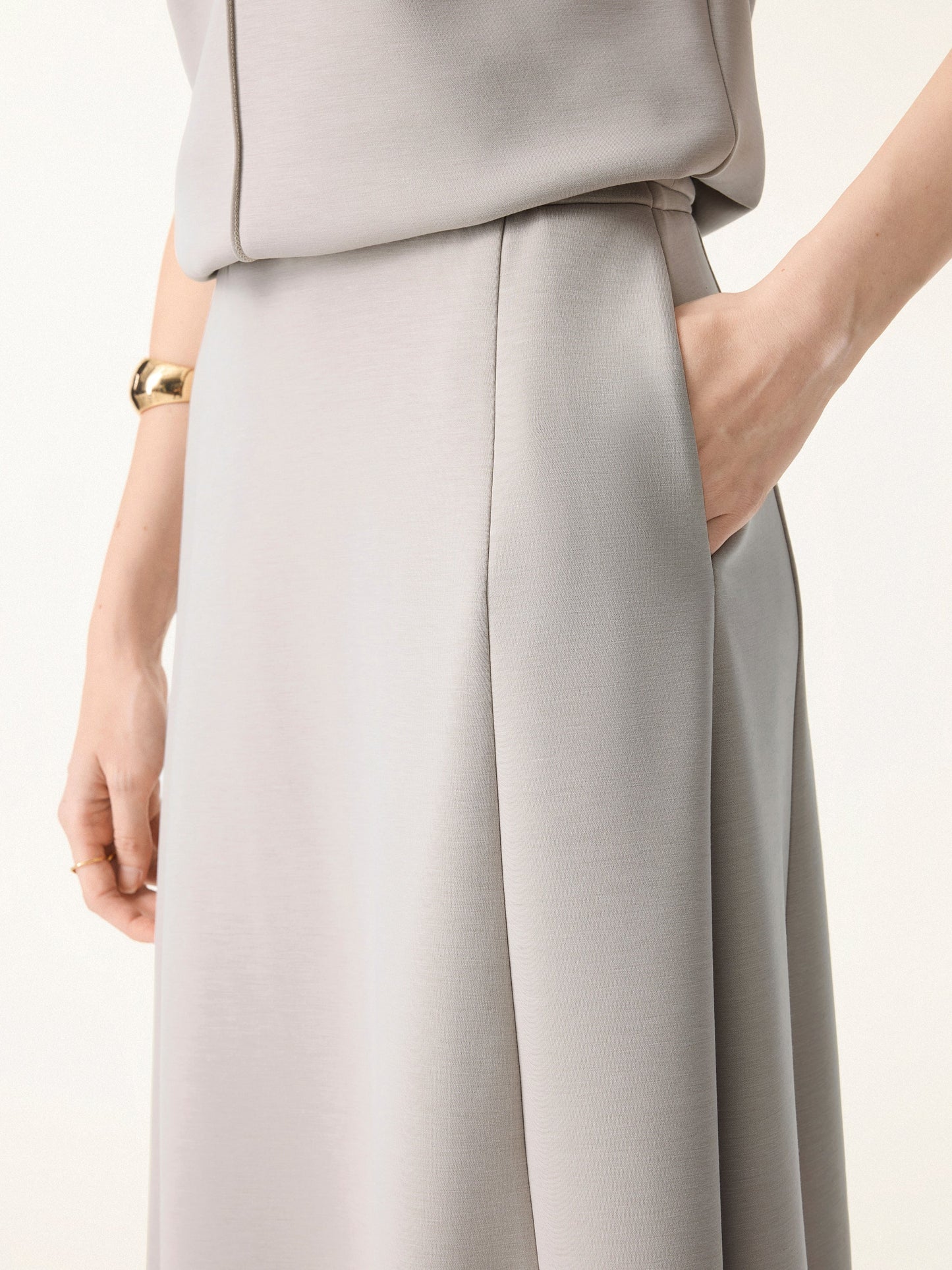 Ensemble deux-pièces avec haut à col en V et jupes midi évasées avec chauffe-manches