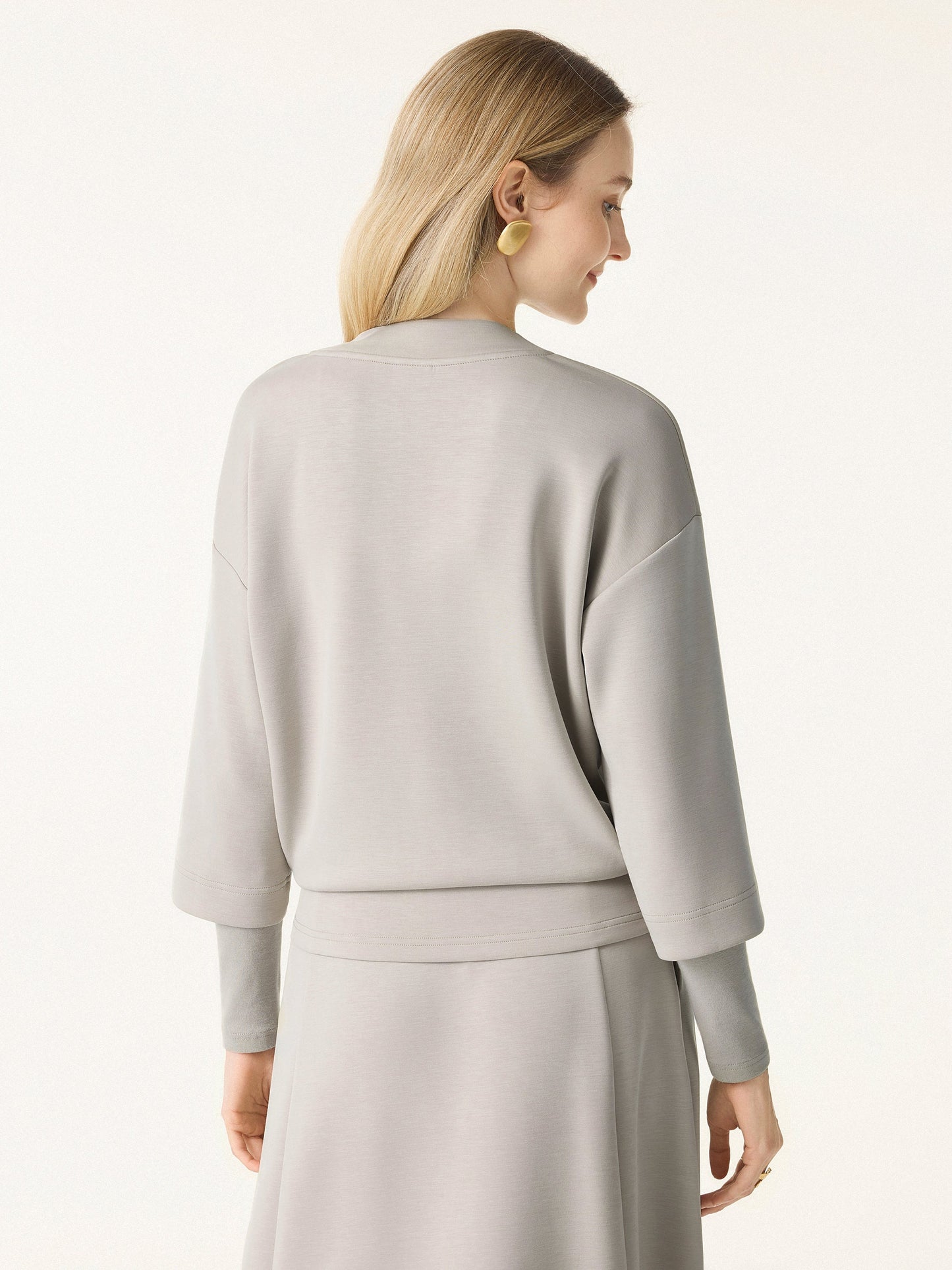 Ensemble deux-pièces avec haut à col en V et jupes midi évasées avec chauffe-manches