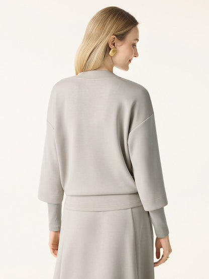 Ensemble deux-pièces avec haut à col en V et jupes midi évasées avec chauffe-manches