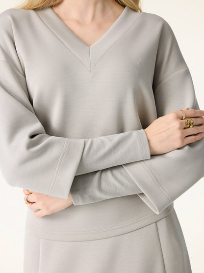 Ensemble deux-pièces avec haut à col en V et jupes midi évasées avec chauffe-manches